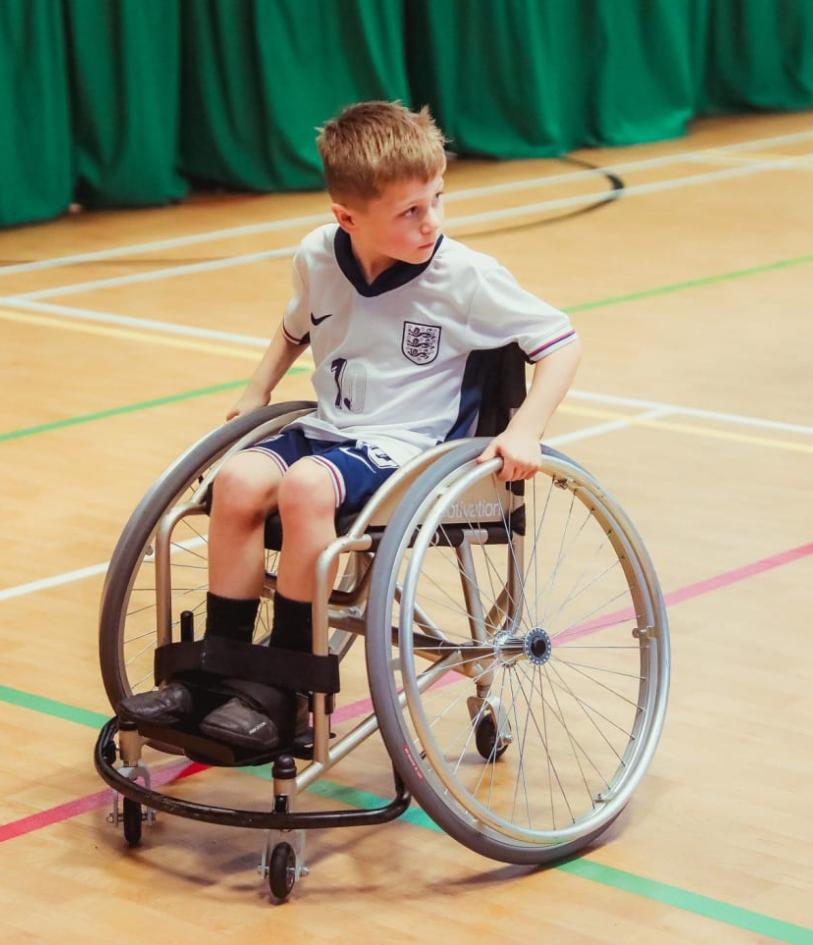 A child in a wheelchair playing wheelchair football