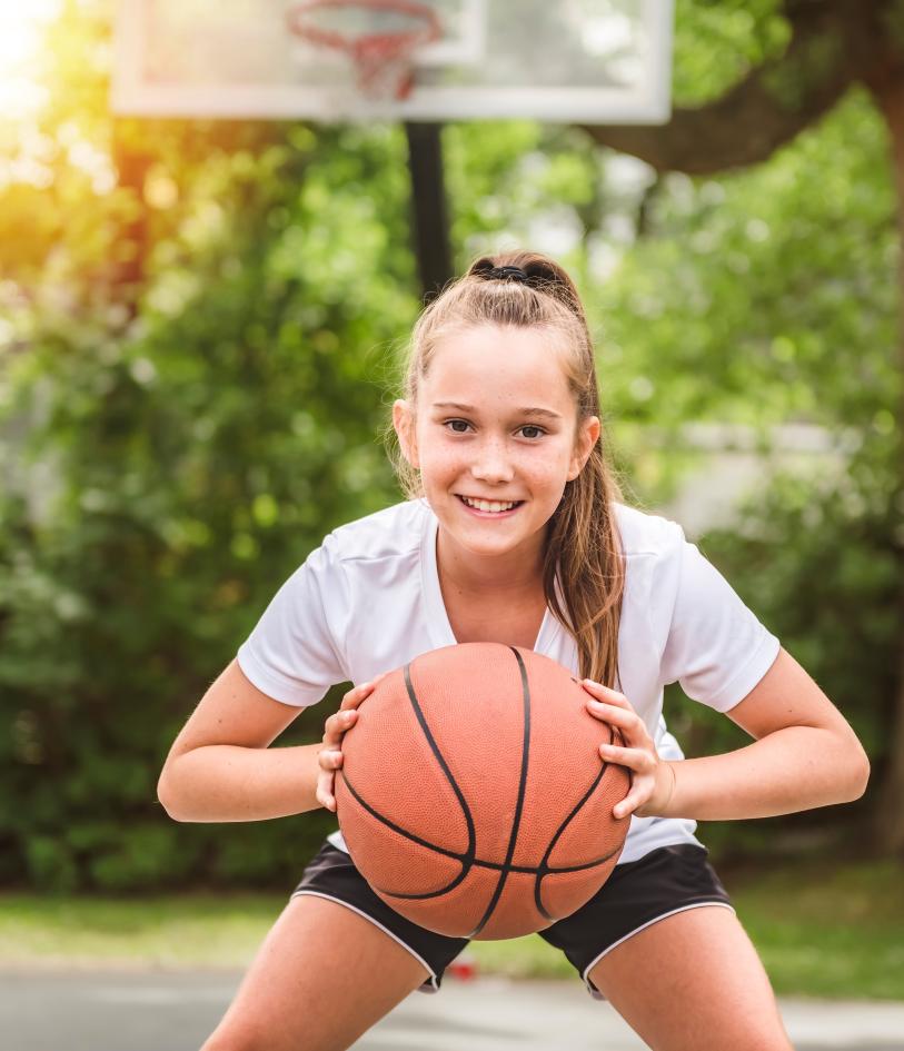 Child holding a basketball on the court